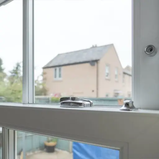 Detailed view of a newly installed, energy saving double glazed sash window looking to small patio area.